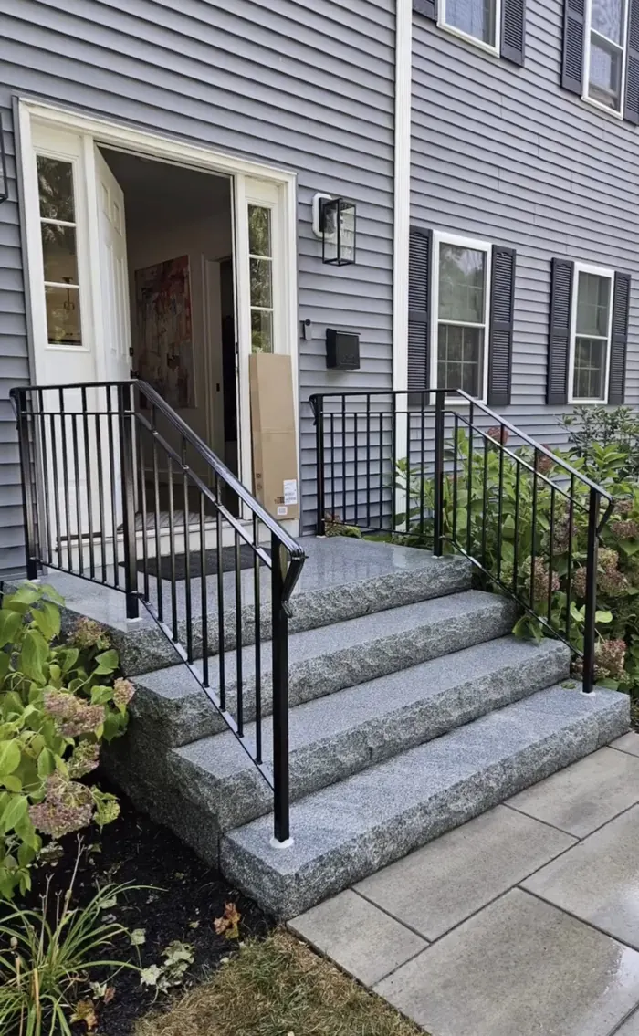 Traditional black baluster railings on granite steps with hydrangeas on both sides